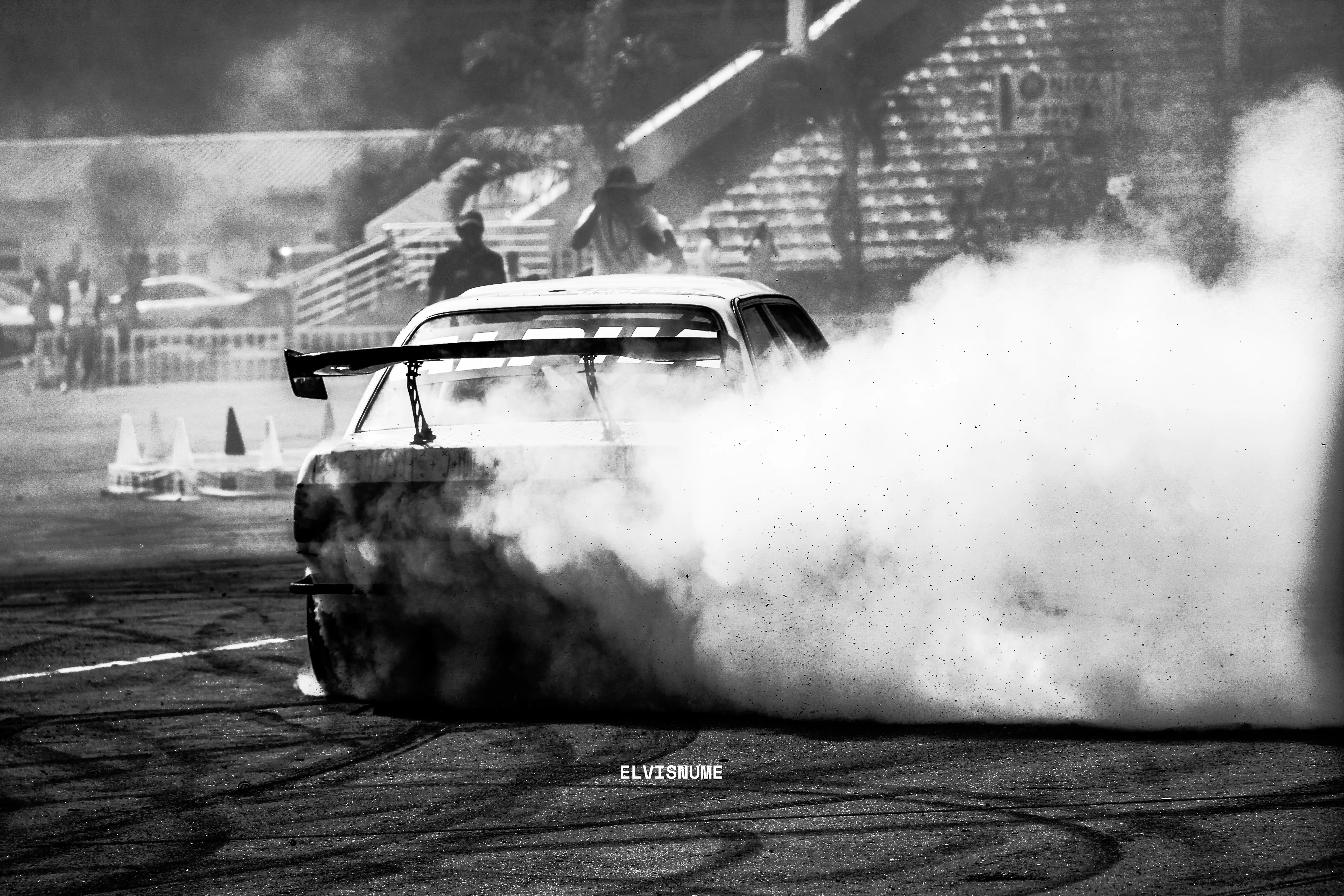 Photograph of a drift car covered in smoke from screeching tires during the NCBA Auto Show Kampala, 2026.