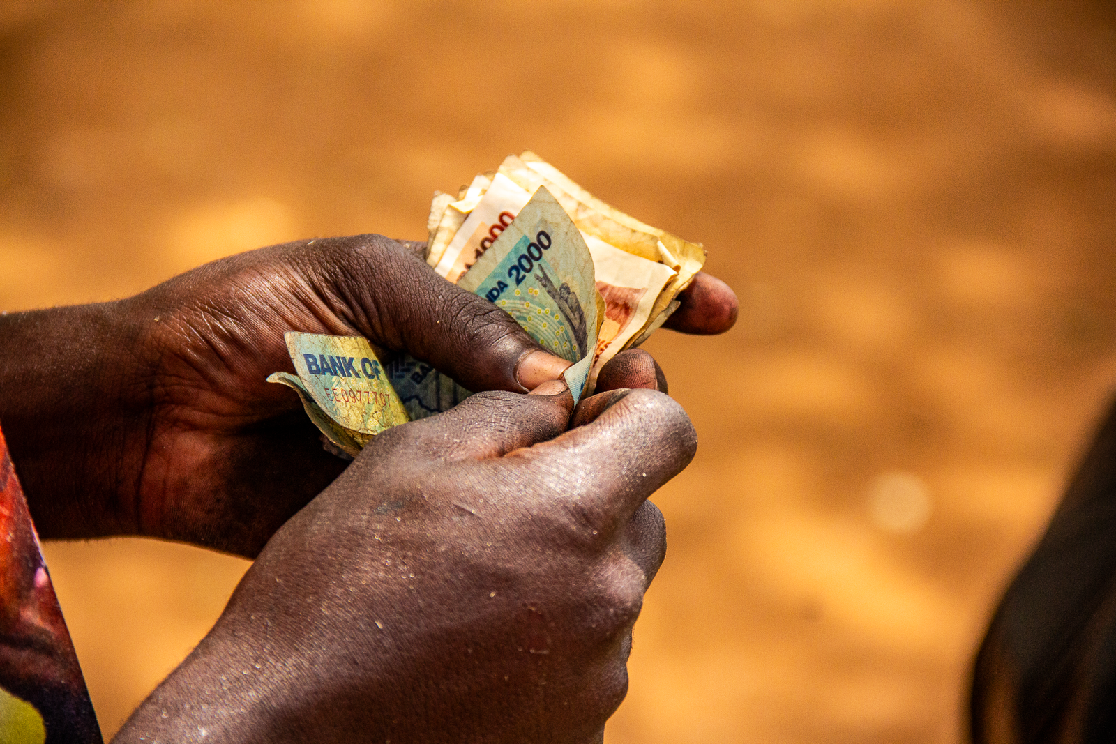 UGANDAN SHILLINGS IN HAND-ELVIS-NUME